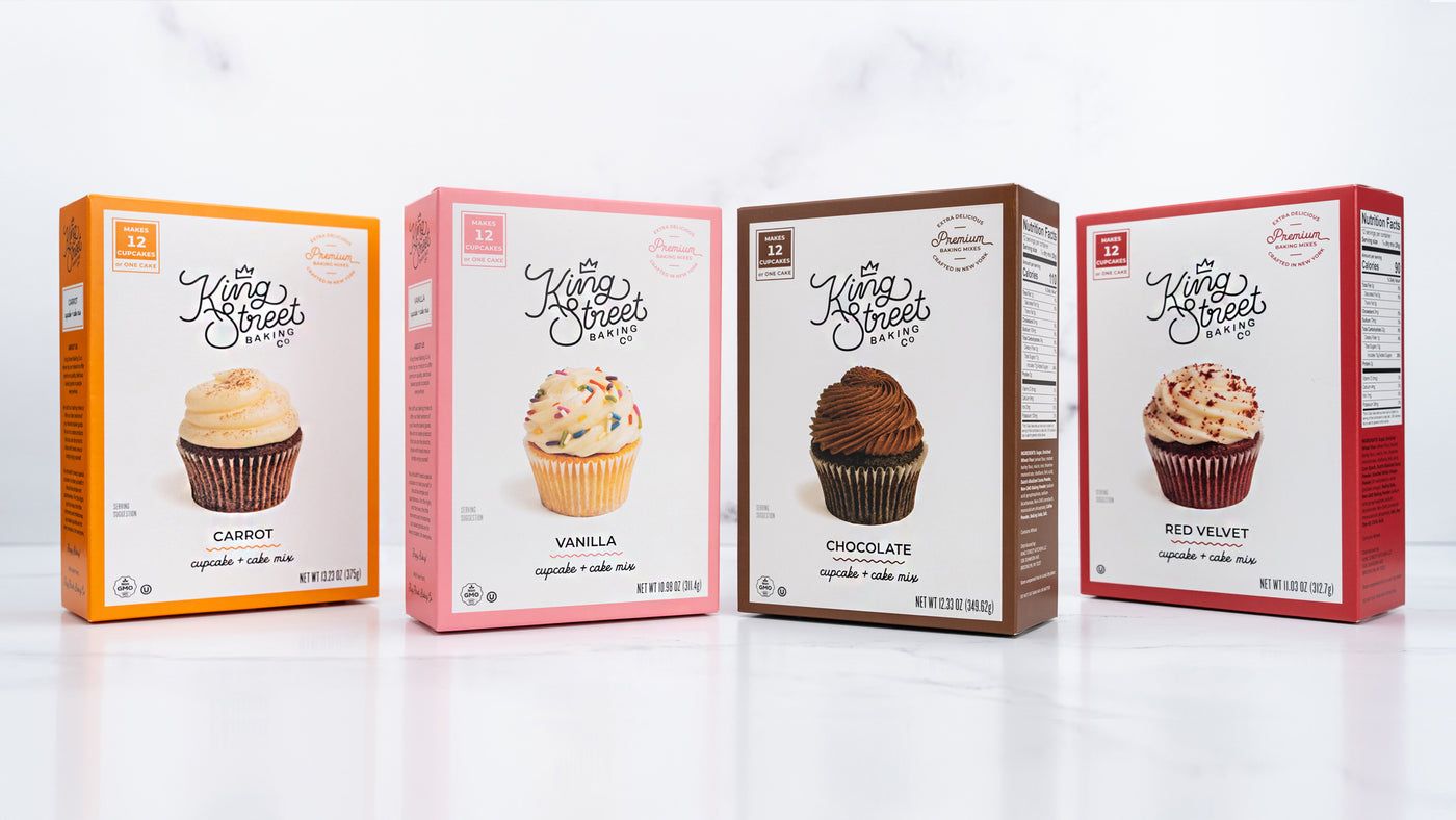 Four boxes of King Street Baking Co cupcake and cake mix on a white marble background.