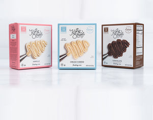 Three boxes of King Street Baking Co frosting mix on a white marble background.
